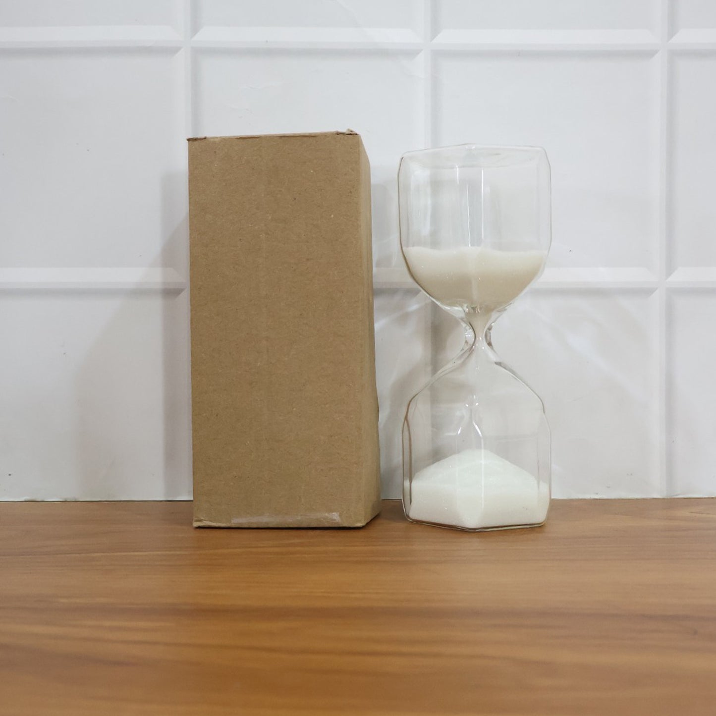 Elegant glass hourglass sand timer for office use by Wukusy, featuring a sleek design and flowing sand inside clear glass.
