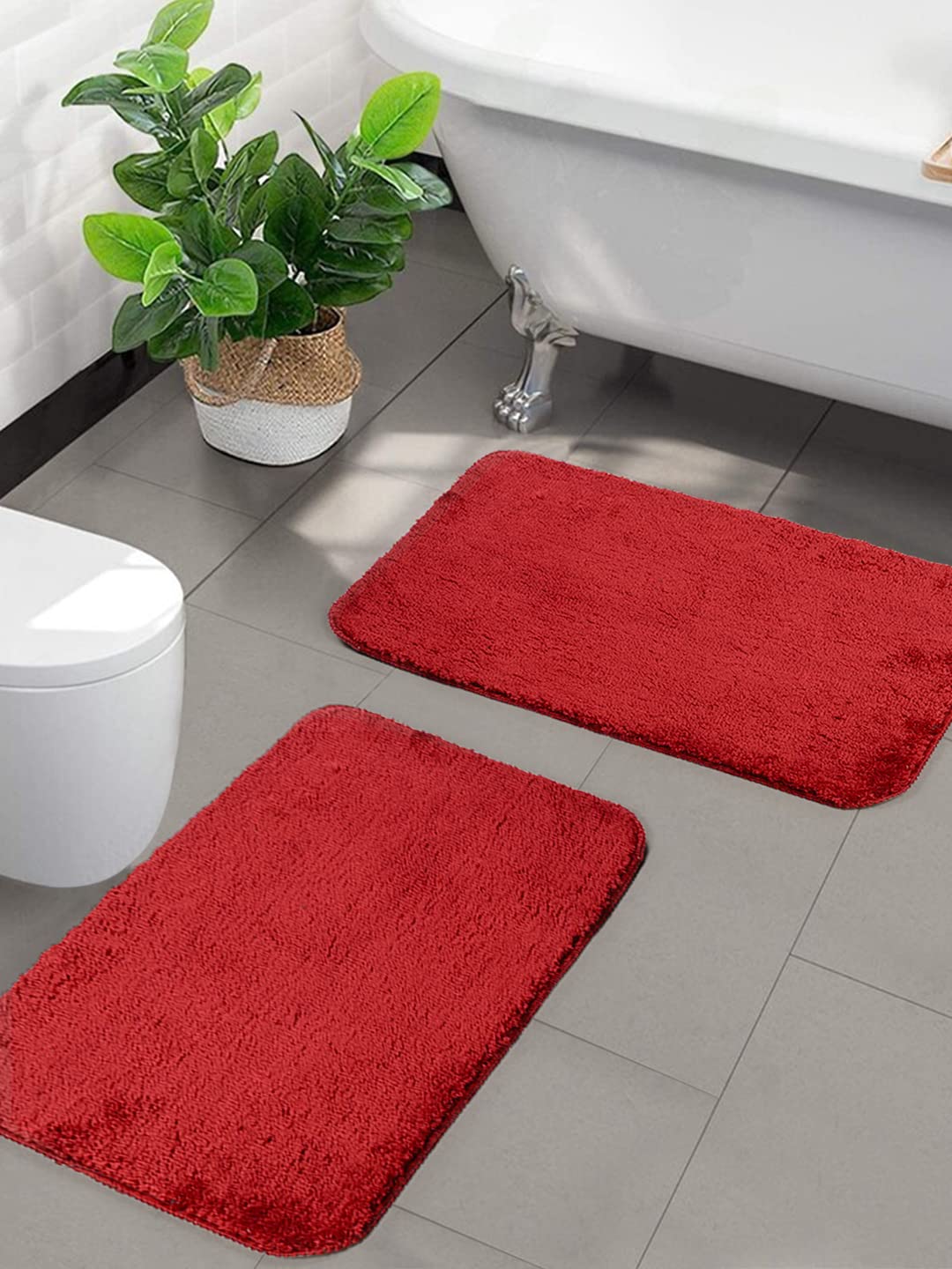 Two red Seasons microfiber anti-skid bath mats laid out on a bathroom floor, showcasing soft texture and non-slip design.