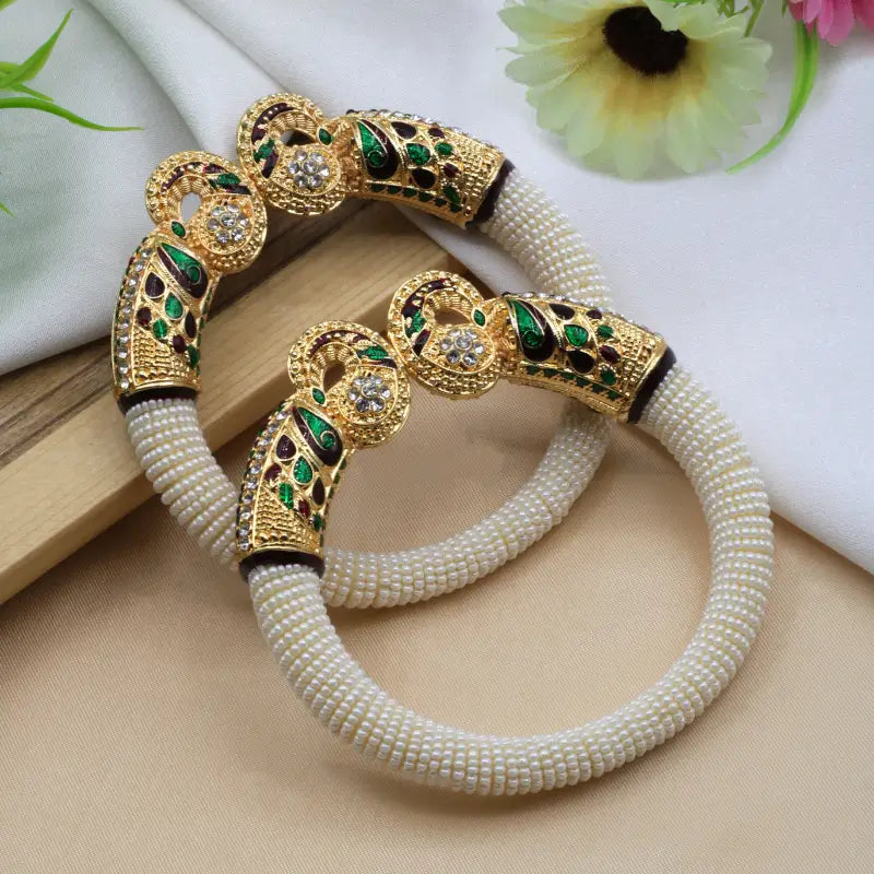 Traditional peacock design pearl bangles for women featuring intricate craftsmanship and elegant silver detailing by Ekom.