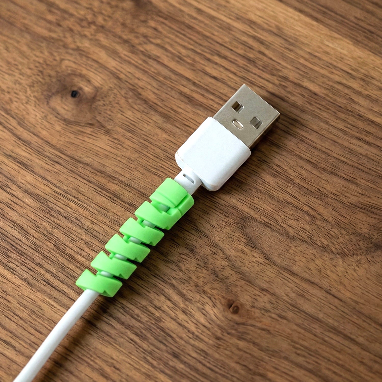 Wukusy spiral cable protector wrapping a charger cable to prevent damage and wear, flexible and easy to install.