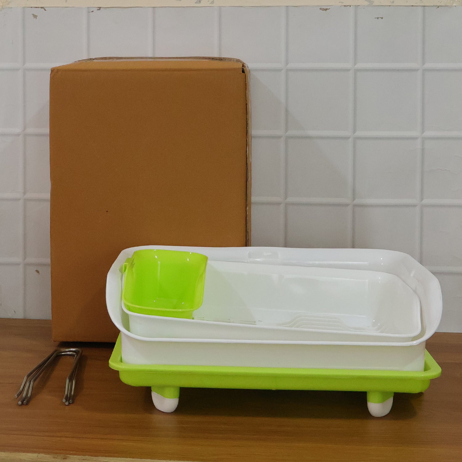 Wukusy Prexo 2-layer kitchen dish drying rack with drain tray, holding plates, cups, and utensils on a countertop.