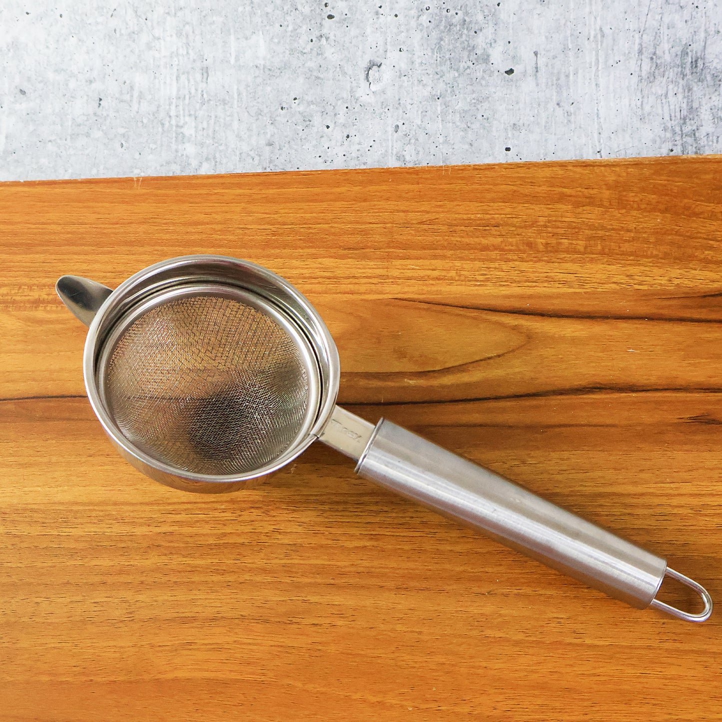Wukusy Supermom Medium Euro Mesh Strainer for kitchen, showing fine mesh and sturdy handle for rinsing and straining food.