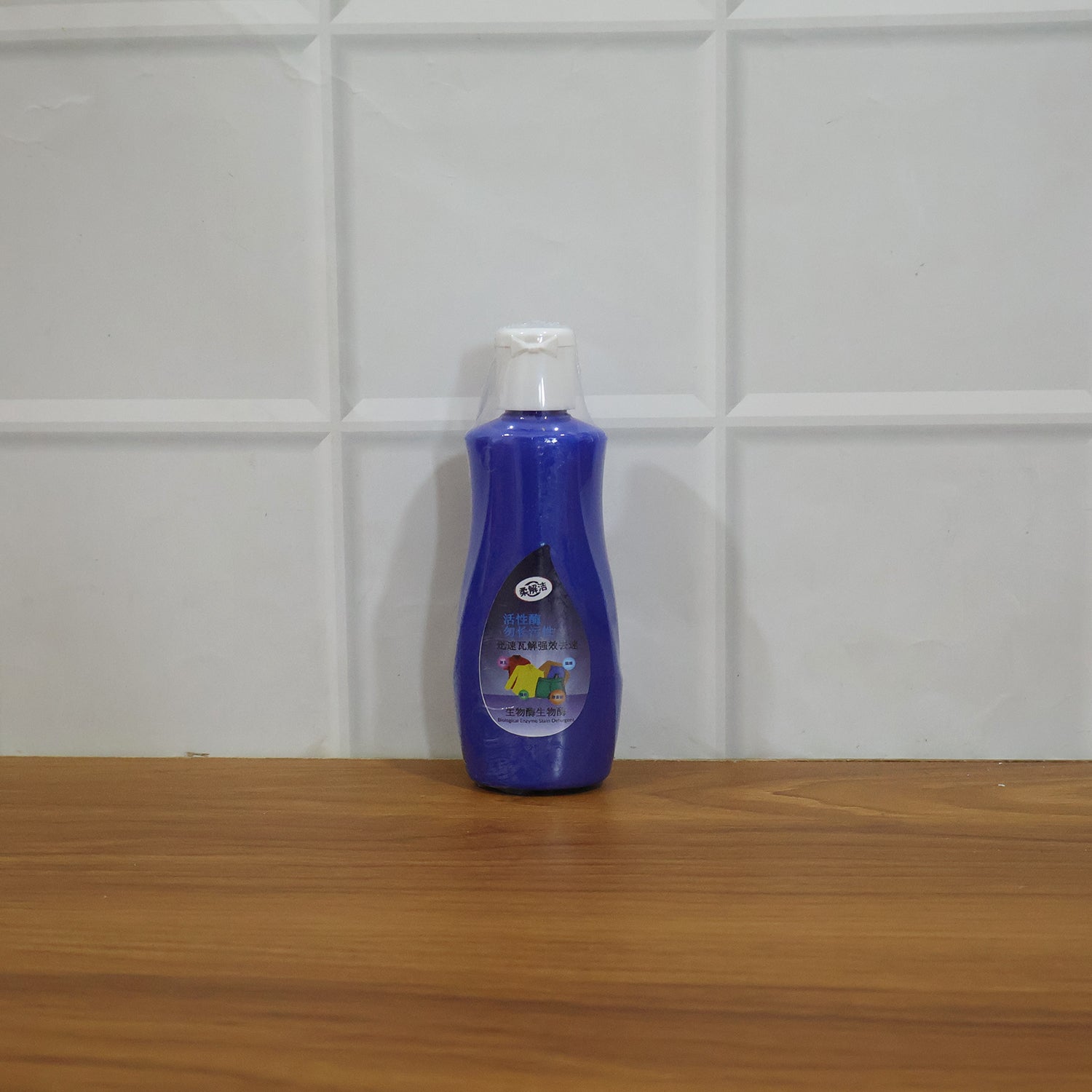 Wukusy multipurpose liquid laundry stain remover bottle, 100 ml, with label showing stain removal application on fabric
