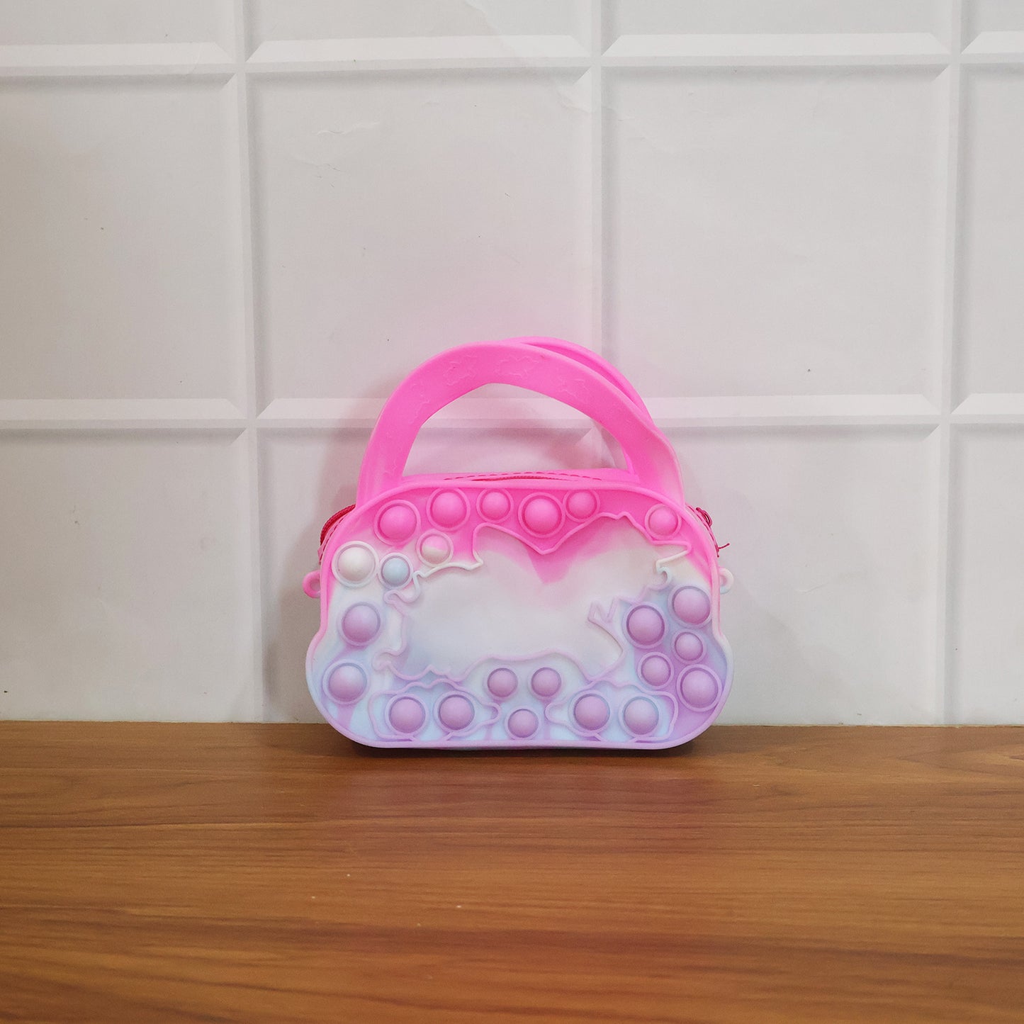 Colorful silicone Pop It coin purse with zipper and handle, designed by Wukusy, featuring a playful bubble sensory fidget toy.