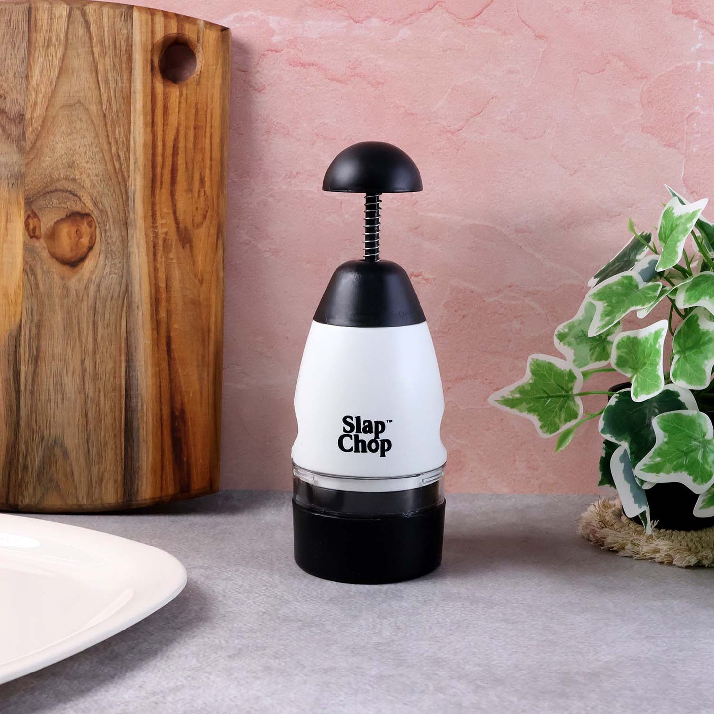 Wukusy Slap Chop hand press vegetable and fruit chopper on a kitchen countertop with chopped produce nearby