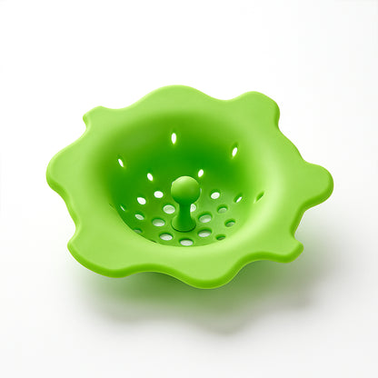 Flexible silicone sink strainer and hair catcher by Wukusy, shown in use over a kitchen drain with water flowing through.