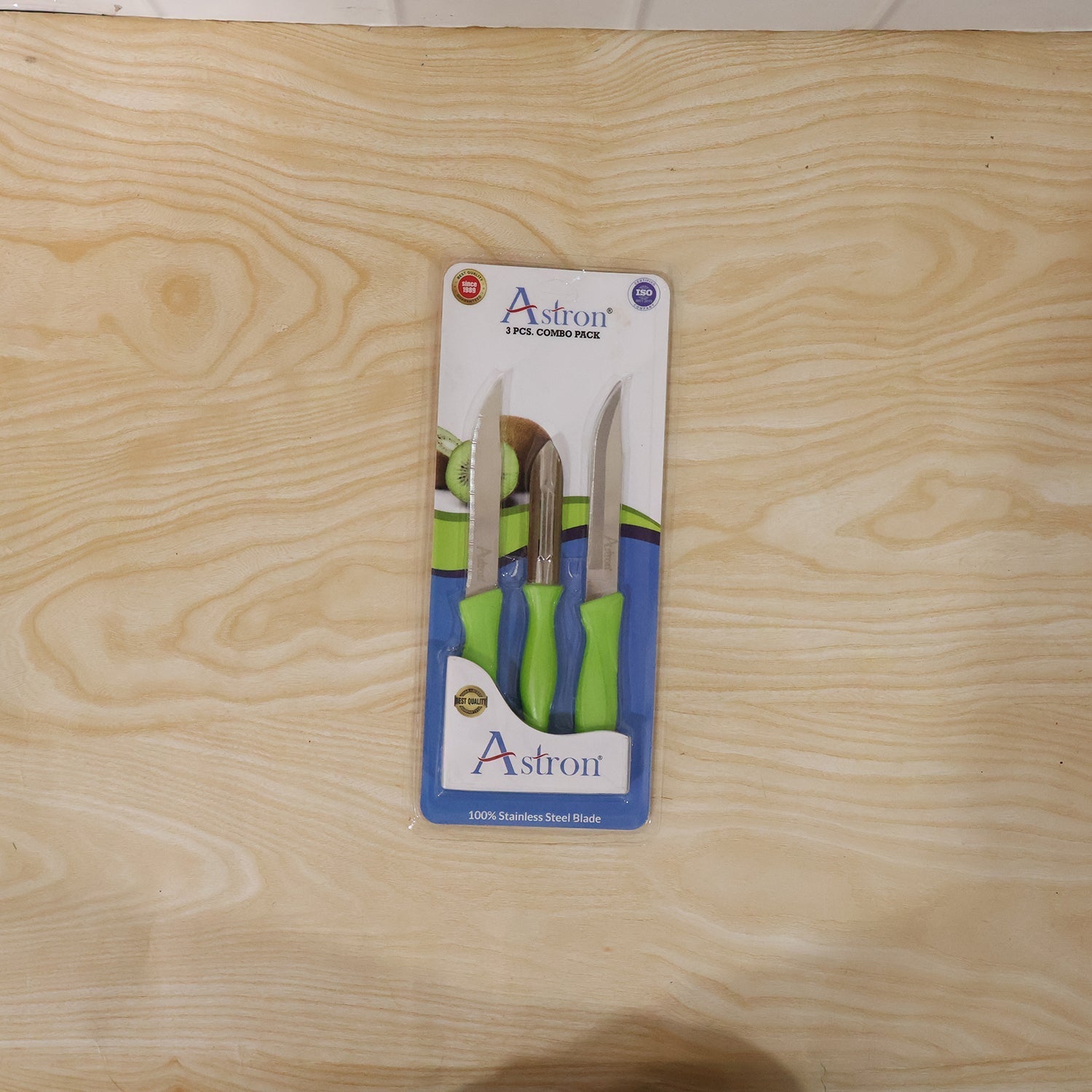 Wukusy stainless steel kitchen knife and peeler combo set, including a chef's knife, paring knife, and peeler, on a wooden cutting board.