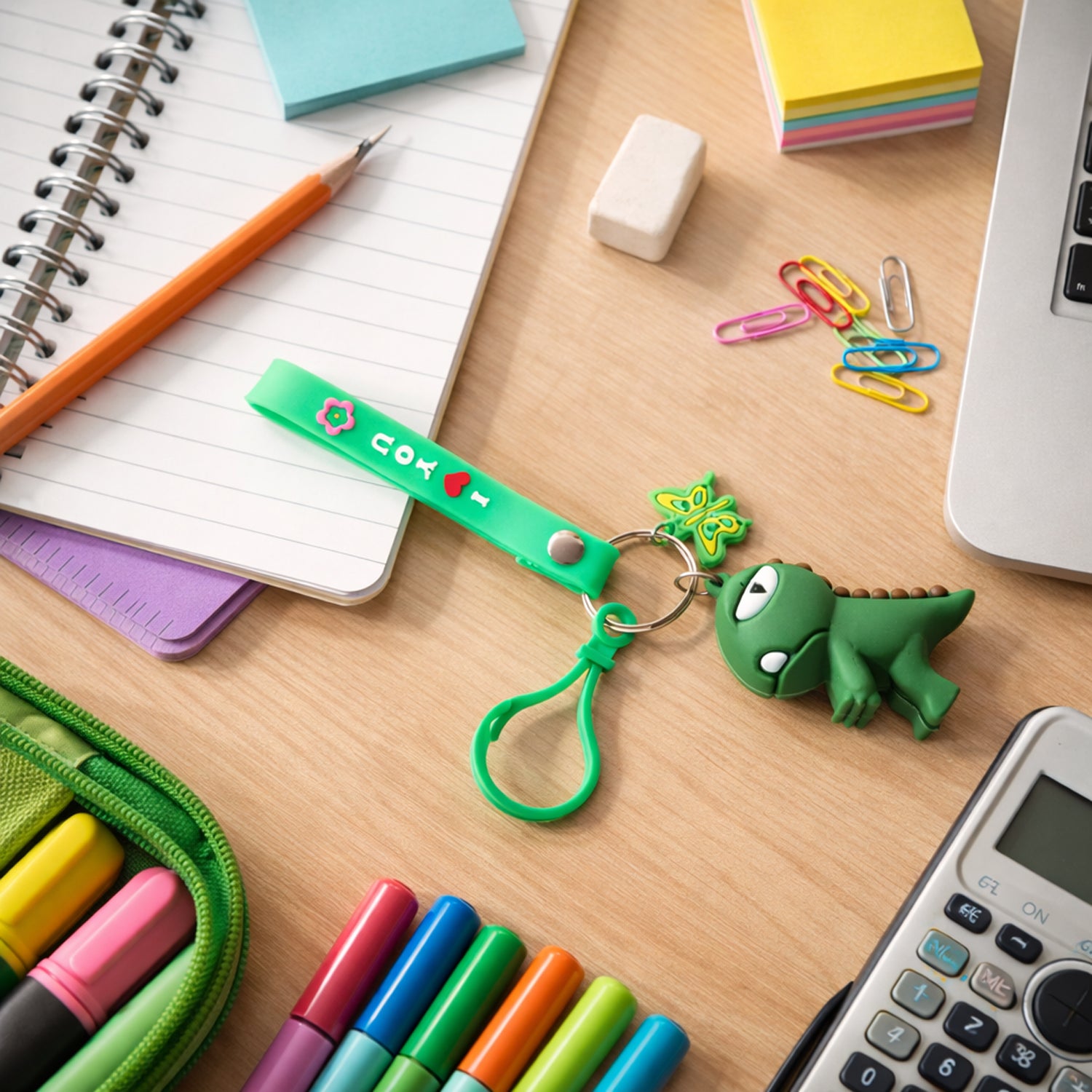 Cute dinosaur cartoon keychain with silicone strap from Wukusy, featuring a colorful dinosaur design and a sturdy keyring.