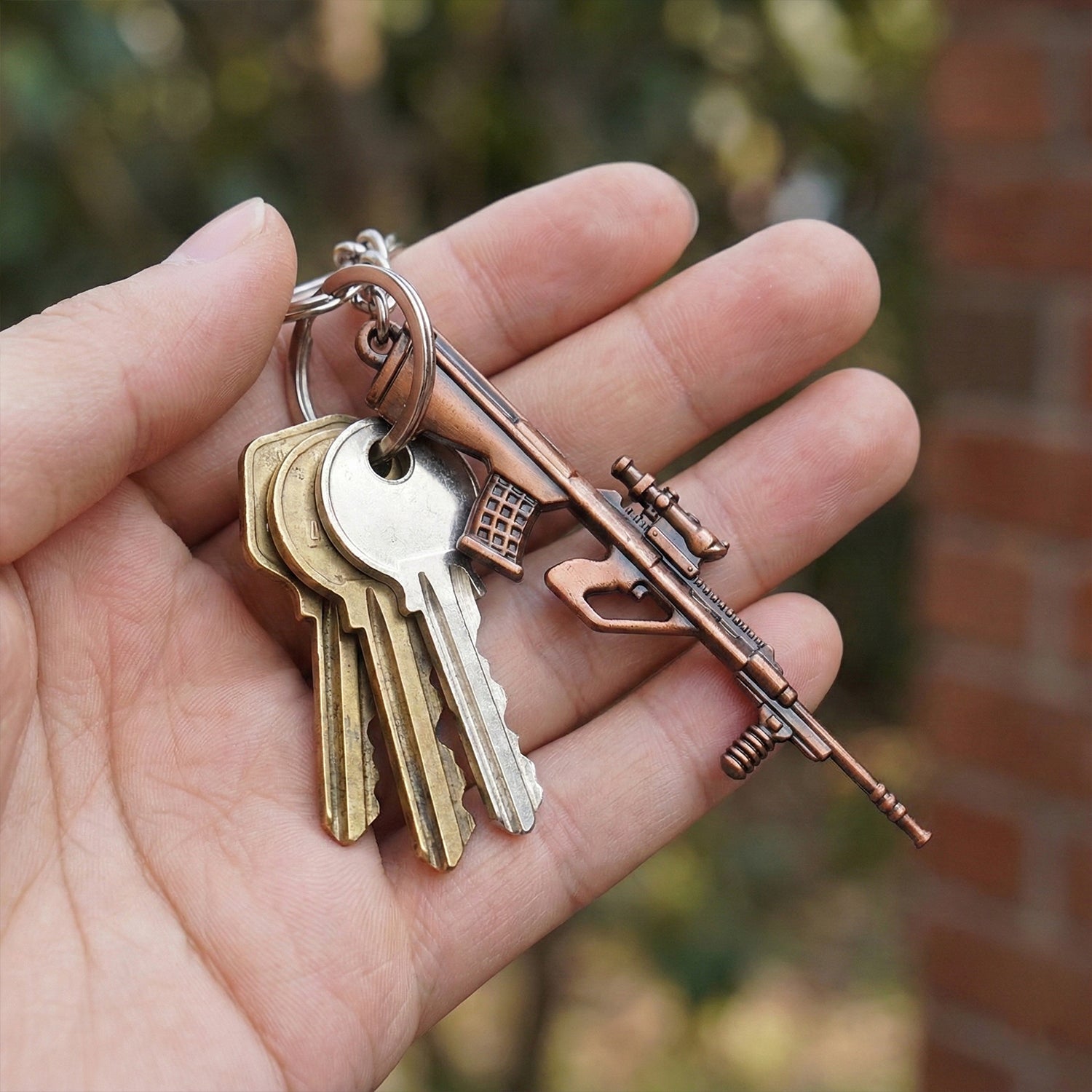 Wukusy metal gun shape keychain with detailed design, attached to a keyring, showcasing a compact and durable accessory.