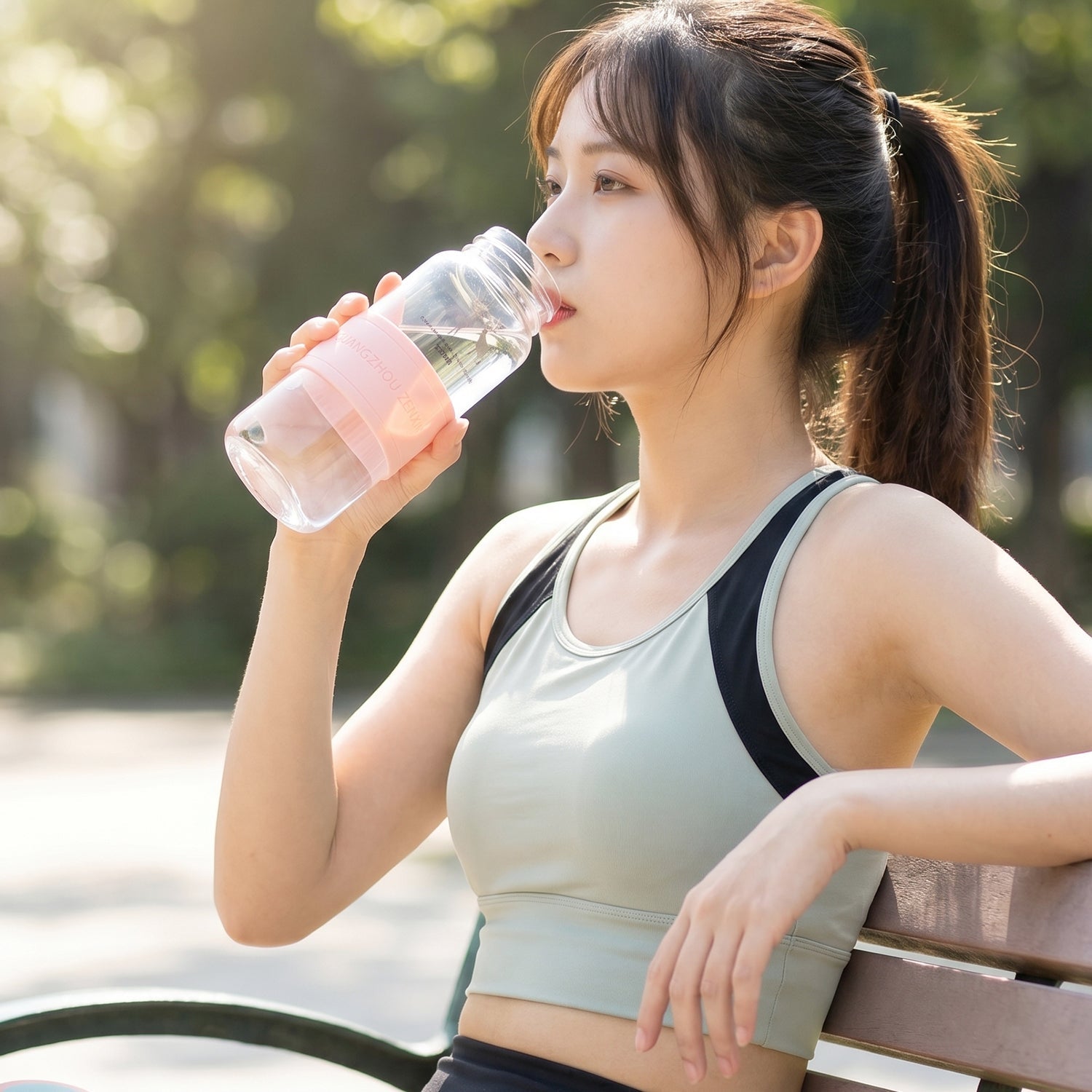 Portable glass water bottle with silicone sleeve and carry strap, 230ml capacity, by Wukusy, shown with strap attached and colorful sleeve.