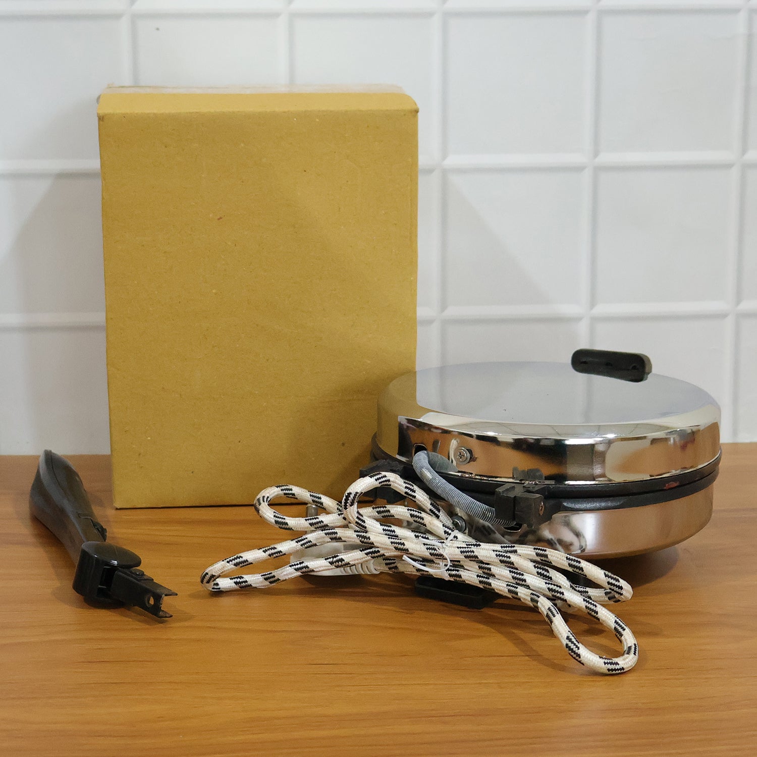Wukusy electric roti maker with stainless steel heating plate for quick, even roti cooking on a compact kitchen appliance.