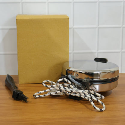 Wukusy electric roti maker with stainless steel heating plate for quick, even roti cooking on a compact kitchen appliance.