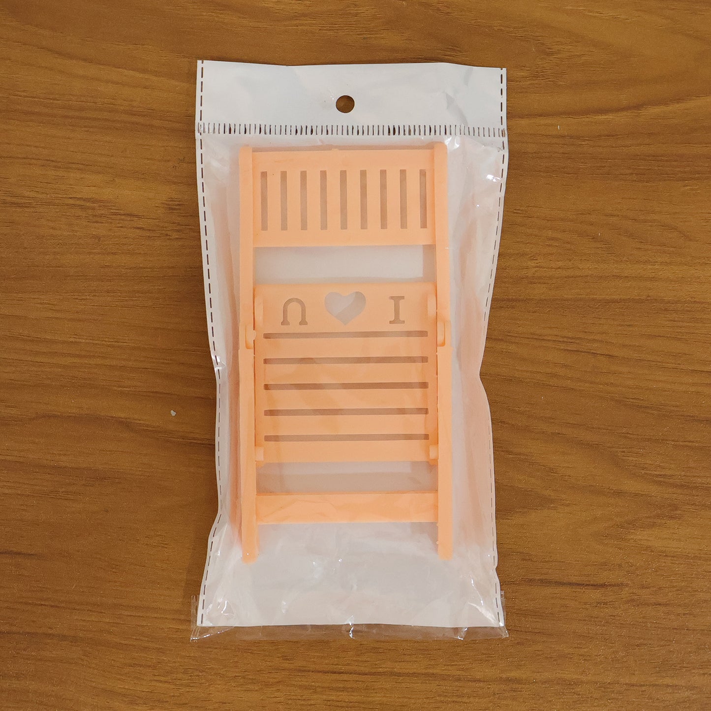 Wukusy mini peach-colored chair-shaped mobile stand holder on a white background, designed to hold smartphones securely.