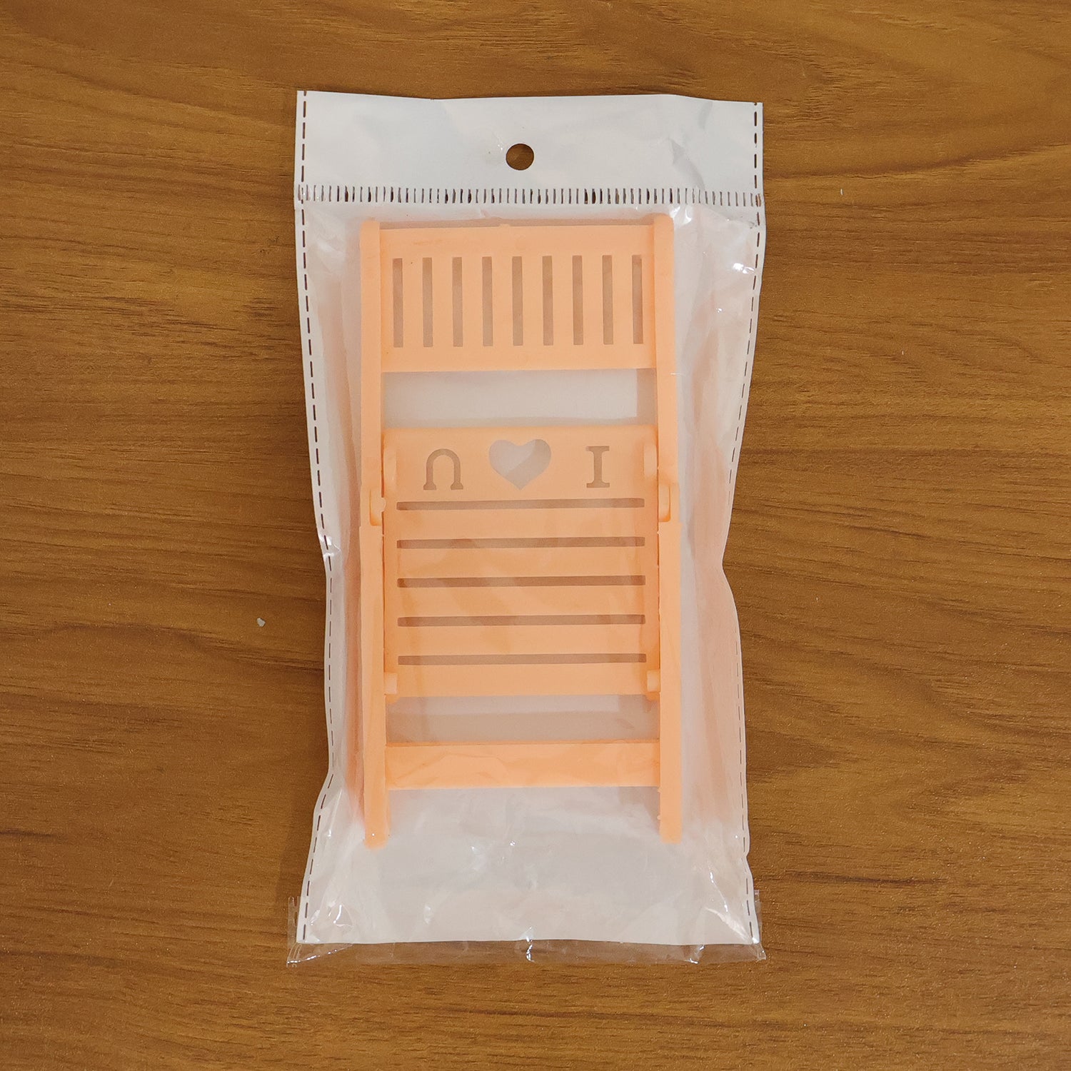 Wukusy mini peach-colored chair-shaped mobile stand holder on a white background, designed to hold smartphones securely.
