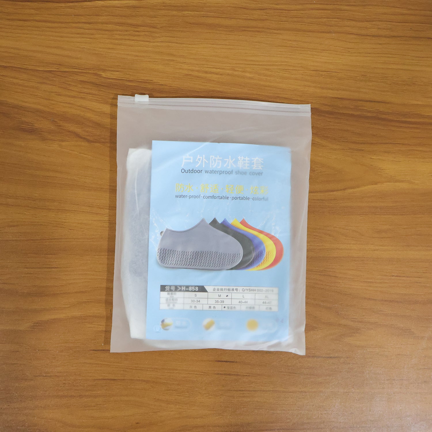 Pair of blue waterproof silicone shoe covers by Wukusy, medium size, shown protecting shoes from water and mud.