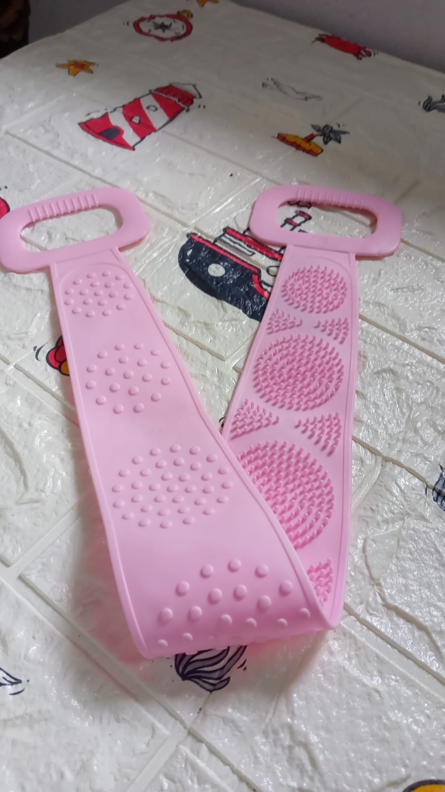 Wukusy 7274 eco-friendly silicone bath body brush towel and back scrubber for shower, showing textured surface and strap for grip.