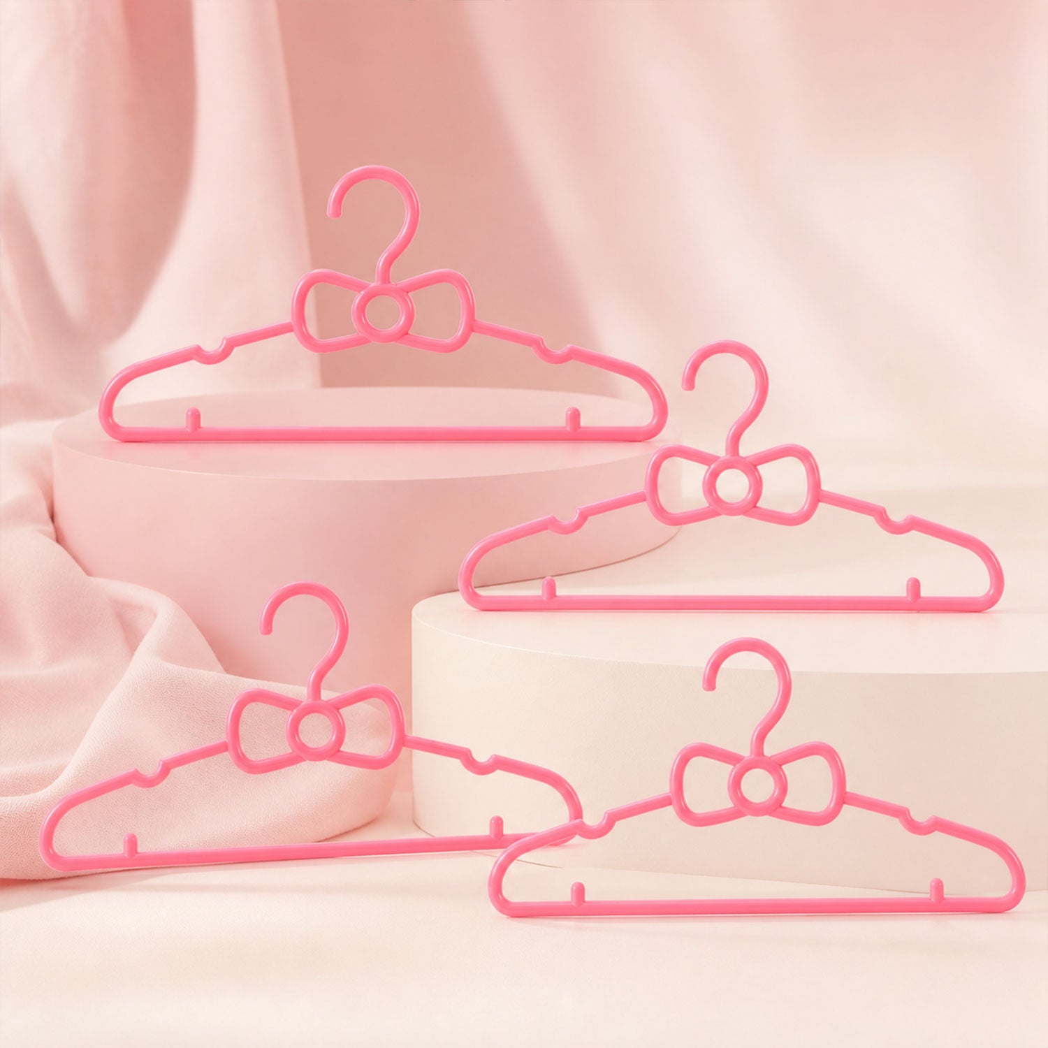 Set of four Wukusy kids plastic clothes hangers with cute bow designs, ideal for baby wardrobes and children's clothing organization.
