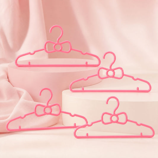 Set of four Wukusy kids plastic clothes hangers with cute bow designs, ideal for baby wardrobes and children's clothing organization.