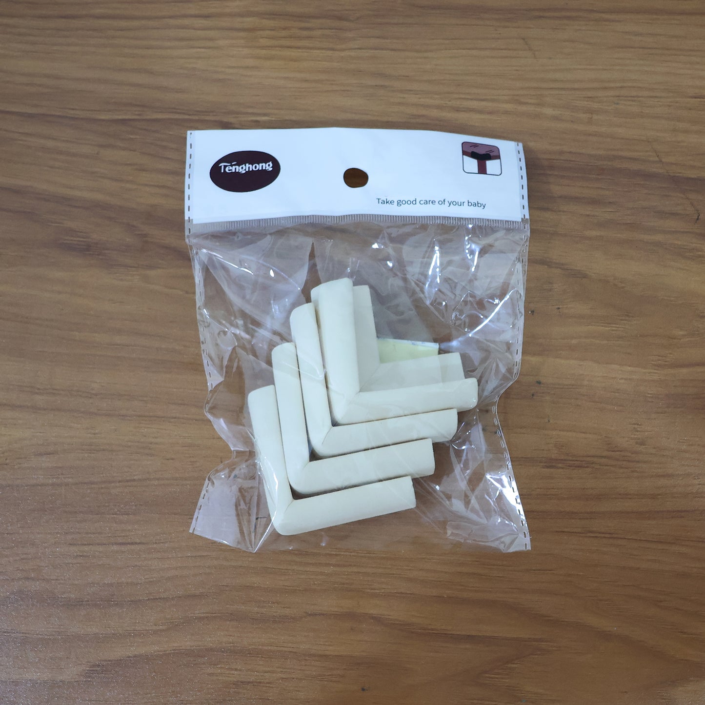 Wukusy 4-piece soft foam table corner protectors set with safety tape for home safety, featuring cushioned corner guards on a wooden table.