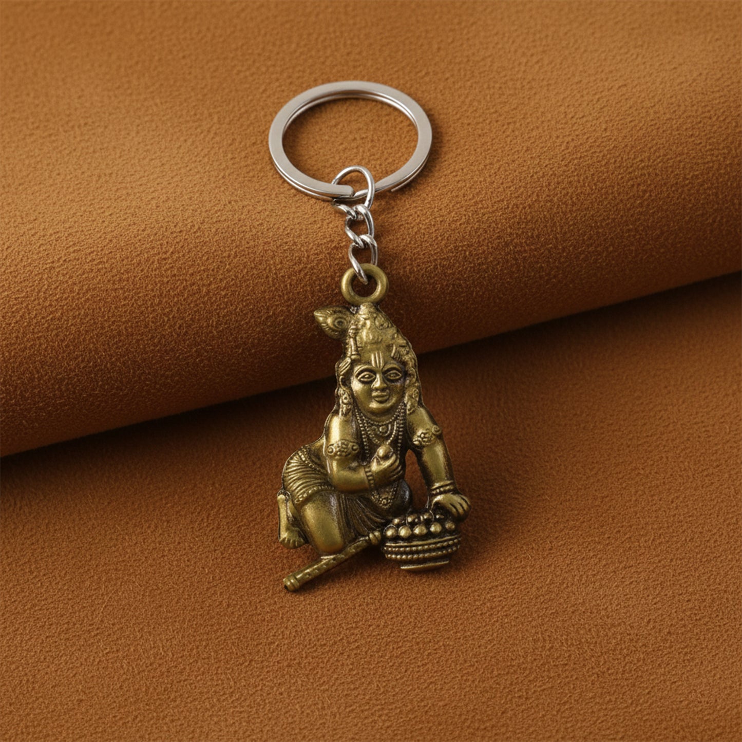Antique gold metal Bal Krishna Makhan Chor keychain with intricate detailing, featuring traditional religious accessories.