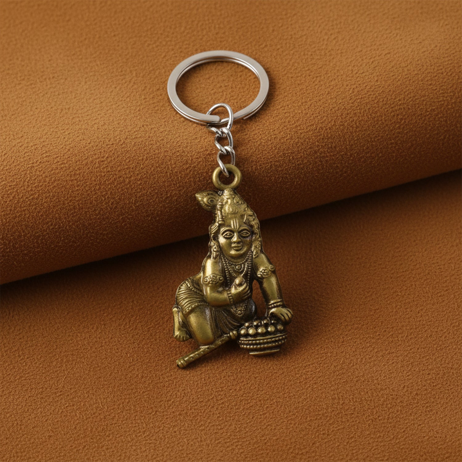 Antique gold metal Bal Krishna Makhan Chor keychain with intricate detailing, featuring traditional religious accessories.