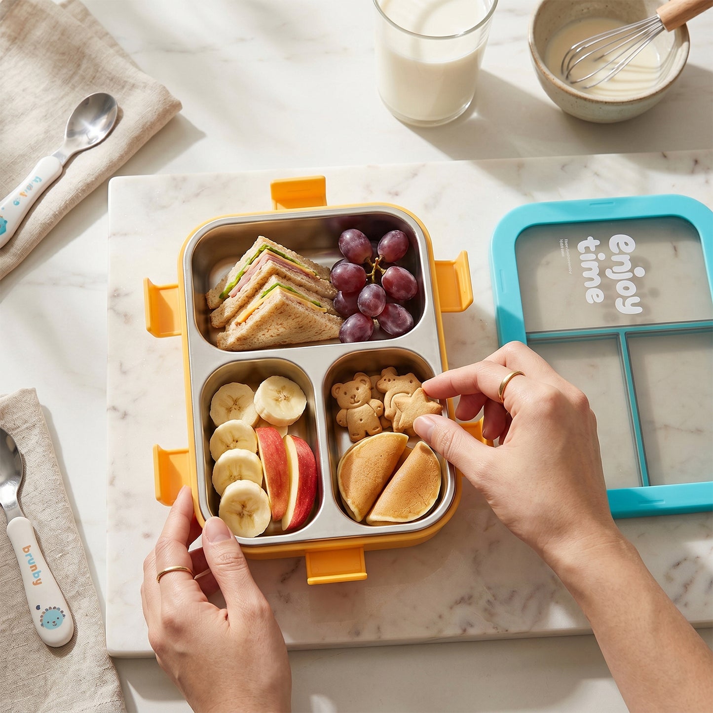 Wukusy stainless steel lunch box with three compartments, 600ml capacity, includes spoon and fork for easy meal packing