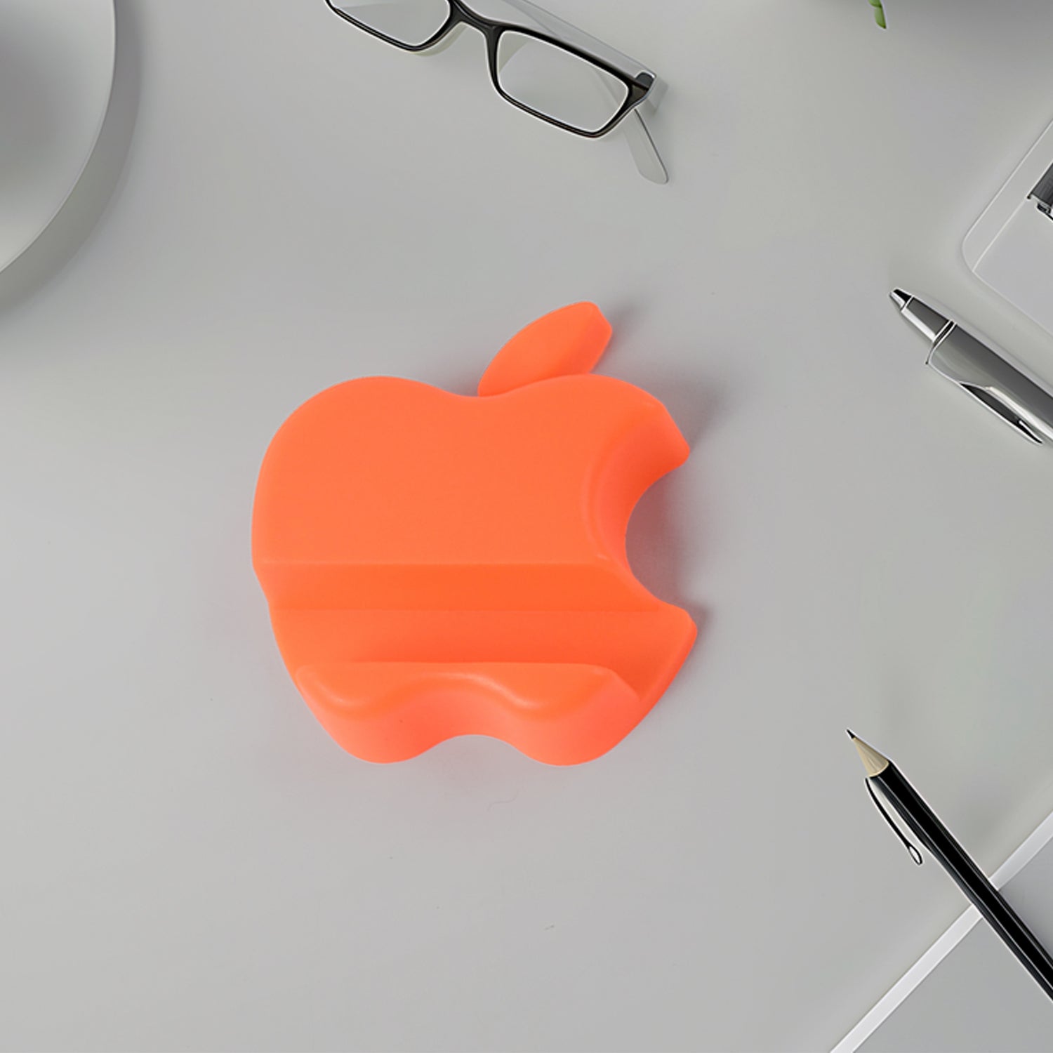 Colorful apple-shaped plastic mobile phone holder by Wukusy, designed to securely hold smartphones on flat surfaces.