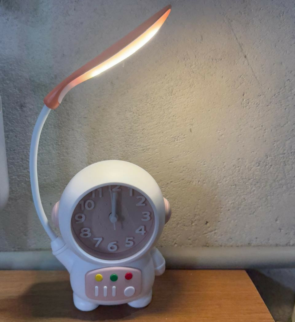 Wukusy astronaut table lamp with clock on a kids' study desk, providing fun lighting and time display for bedrooms and study areas.