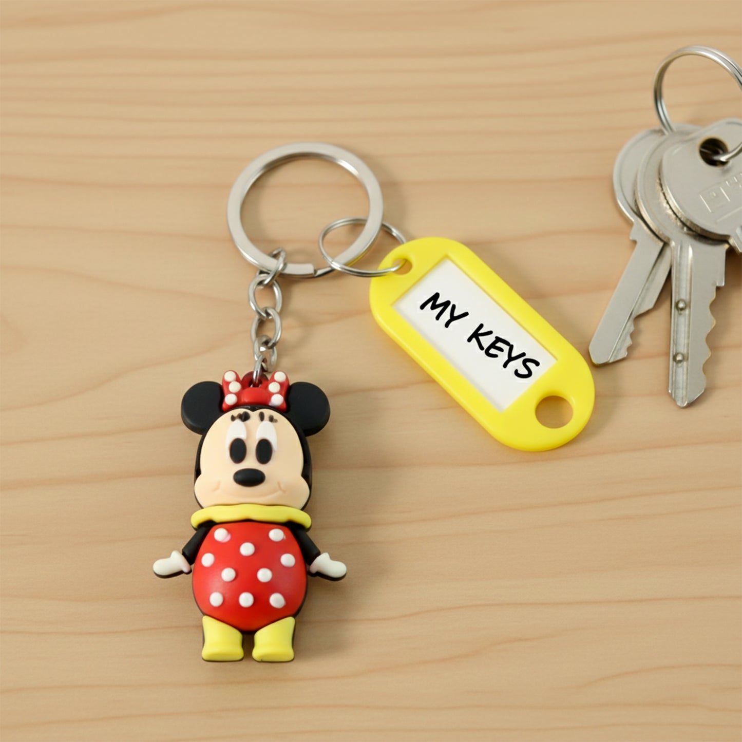 Cartoon character keychain with attached name tag from Wukusy, featuring a colorful, playful design on a keyring.
