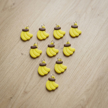 Set of 10 Wukusy banana-shaped bag charm keychains featuring cute, colorful designs for accessories and bags.