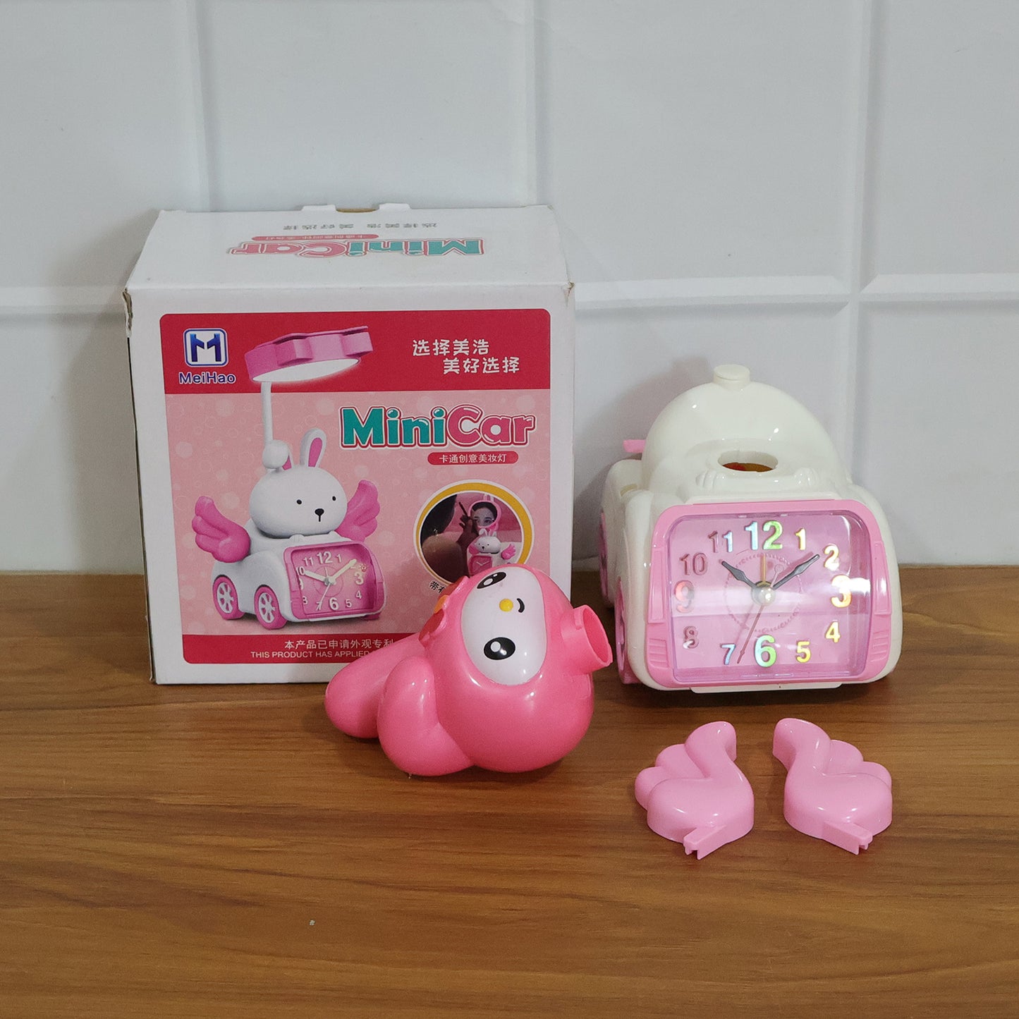 Pink cartoon bunny car-style table alarm clock by Wukusy featuring a cute bunny design and digital display.