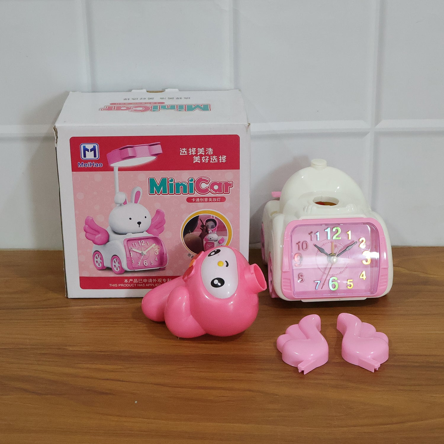 Pink cartoon bunny car-style table alarm clock by Wukusy featuring a cute bunny design and digital display.