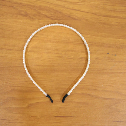 Elegant pearl beaded slim golden metal hair band by Wukusy, featuring delicate pearl accents and a sleek design for stylish hair accessories.