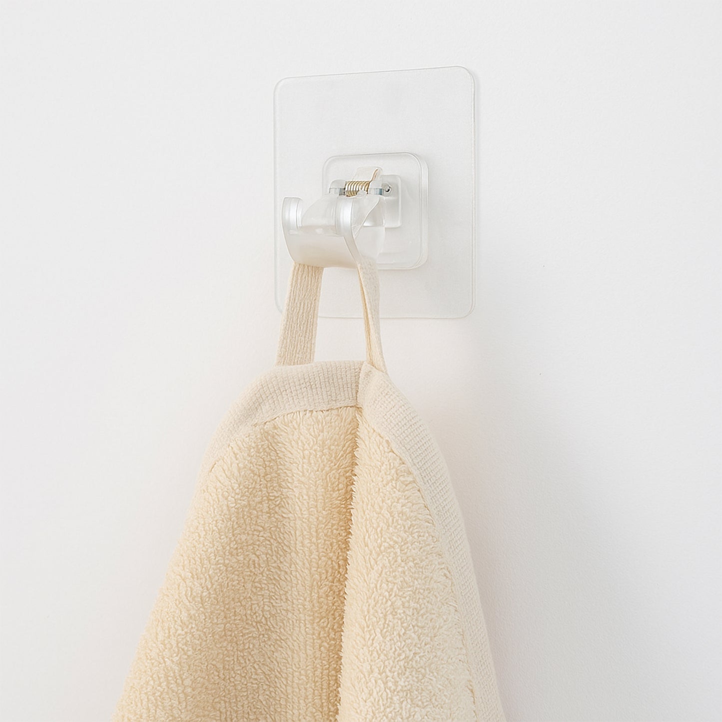 Transparent self-adhesive wall hook holder clip by Wukusy, shown attached to a wall for hanging lightweight items.