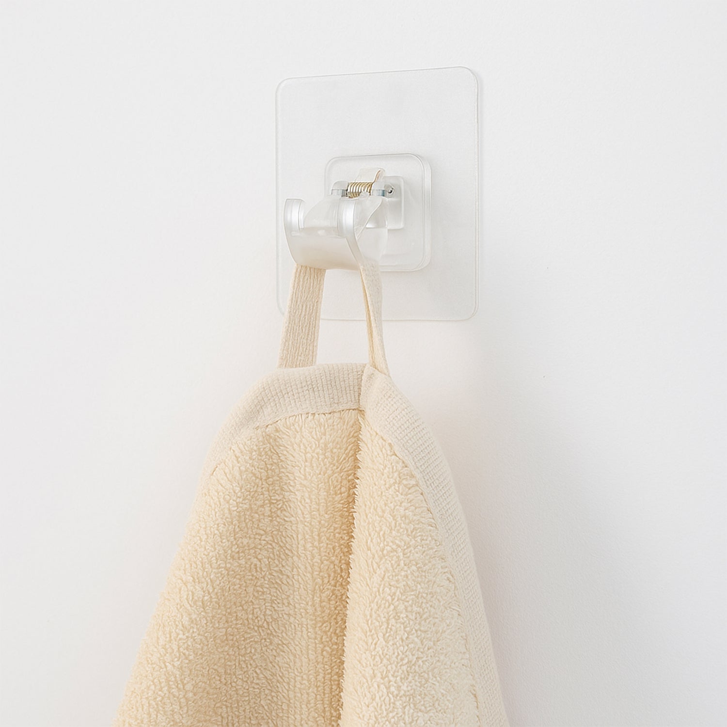 Transparent self-adhesive wall hook holder clip by Wukusy, shown attached to a wall for hanging lightweight items.