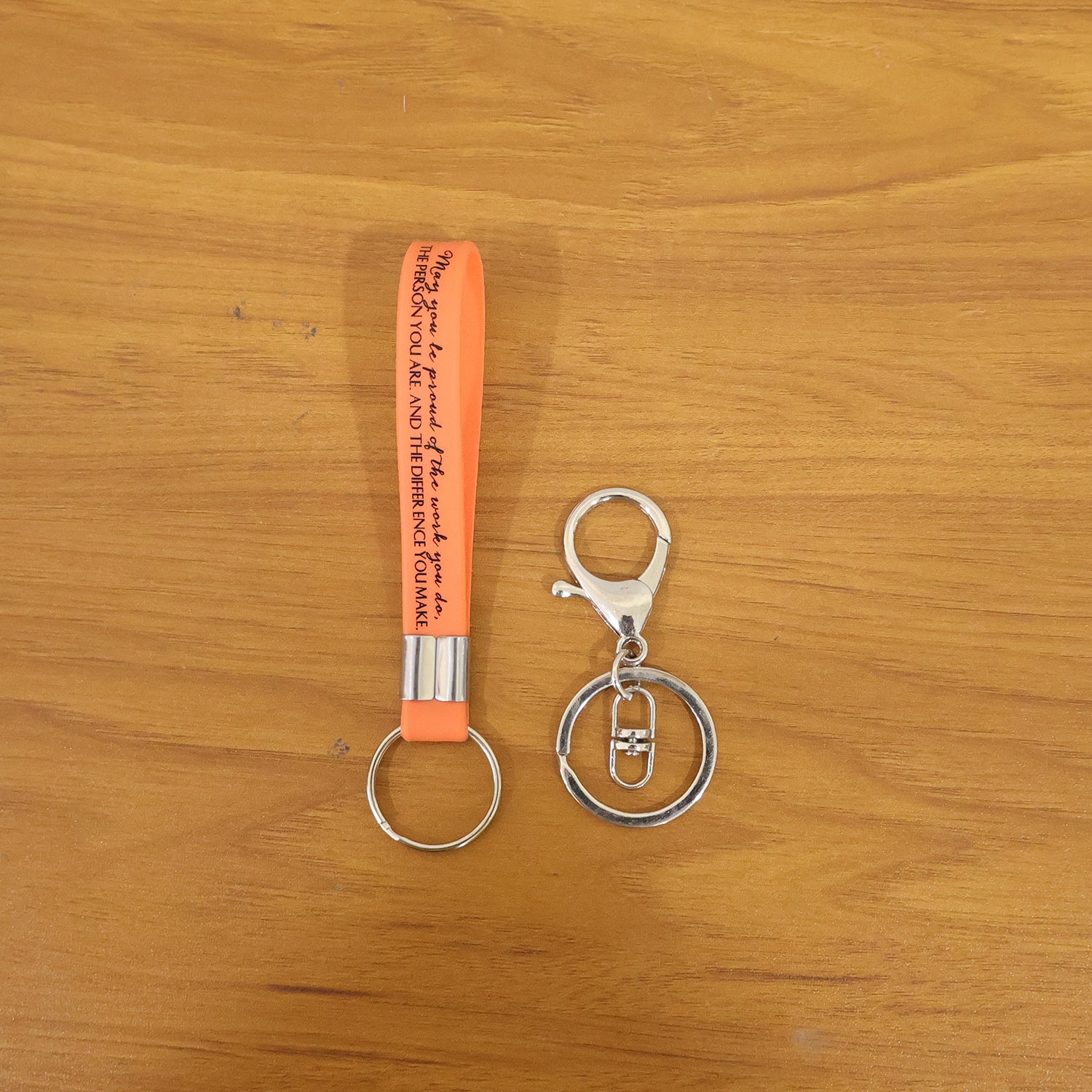 Two Wukusy silicone wrist strap keychains with metal key ring hooks, shown with colorful silicone straps and sturdy metal rings.