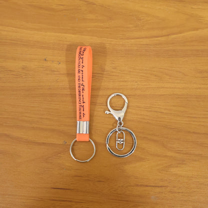 Two Wukusy silicone wrist strap keychains with metal key ring hooks, shown with colorful silicone straps and sturdy metal rings.