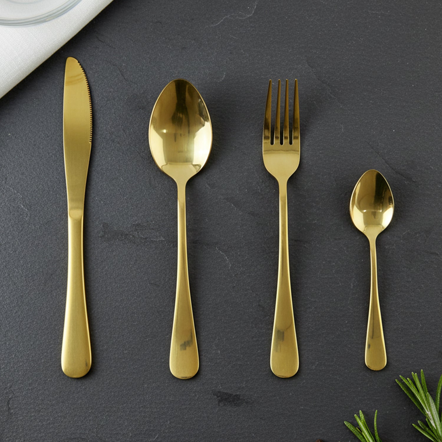 Wukusy stainless steel golden cutlery set with 24 pieces arranged on a pineapple-shaped storage stand, stylish and modern dining essentials
