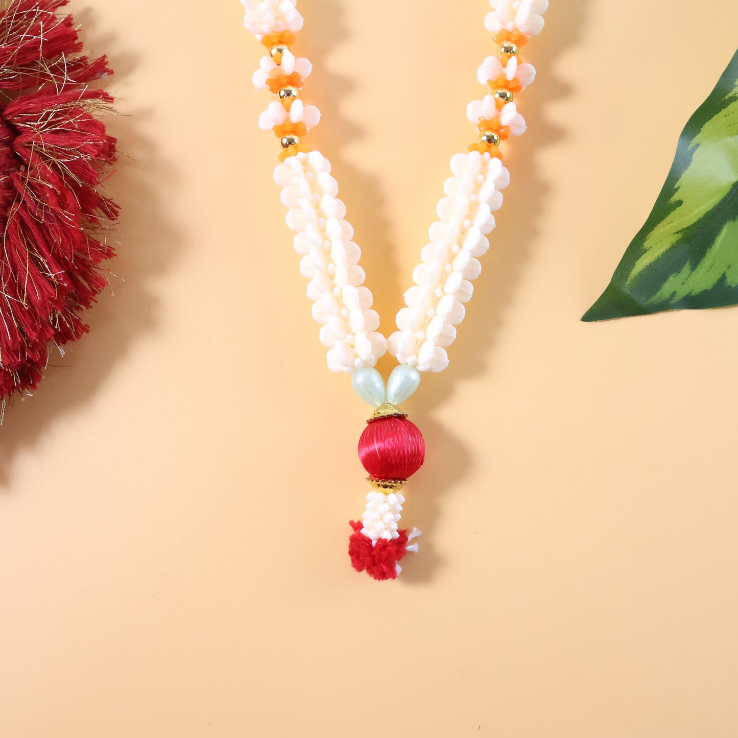 Traditional decorative pooja gajra garland by Wukusy, floral string for religious ceremonies, shown hanging with vibrant flowers.