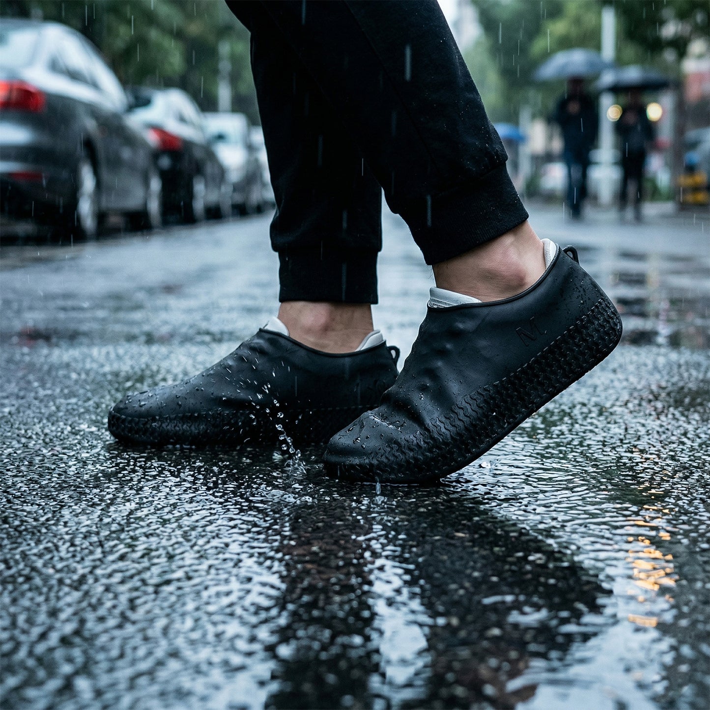 Pair of black Wukusy waterproof silicone shoe covers in medium size, designed to protect shoes from water and dirt.
