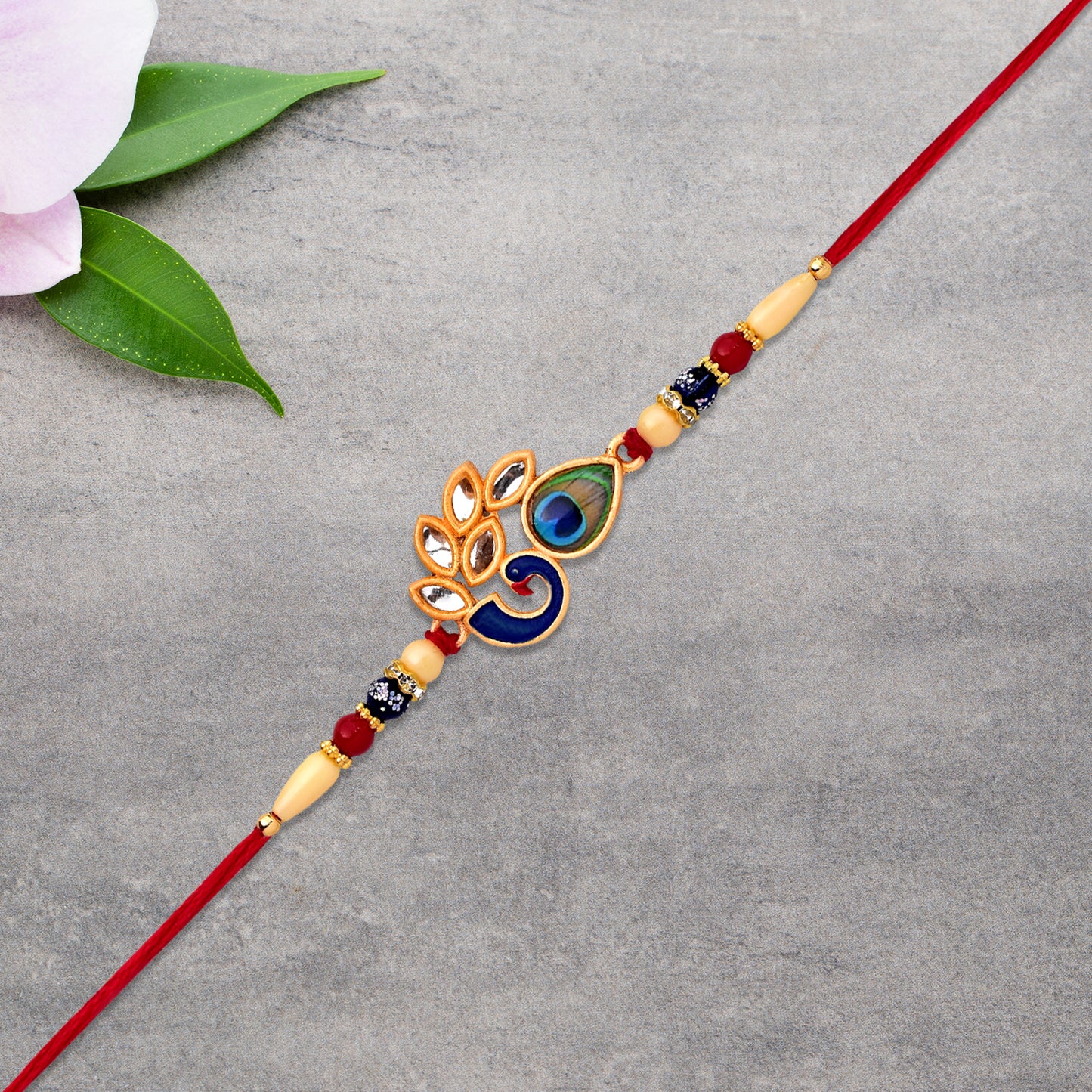 Colorful enamel artistic Mor Pankh Rakhi with traditional thread, designed by Wukusy for festive fashion and celebration.