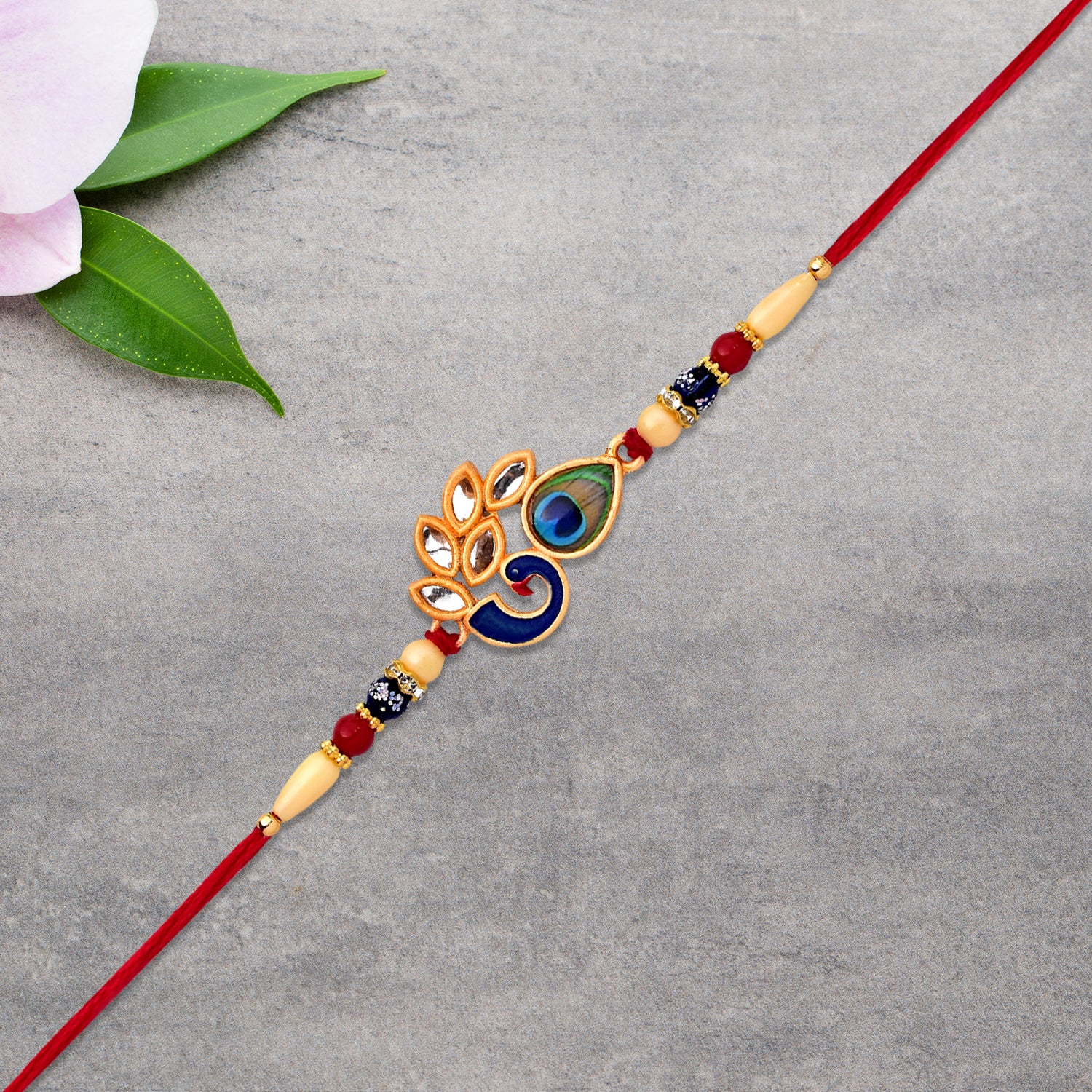 Colorful enamel artistic Mor Pankh Rakhi with traditional thread, designed by Wukusy for festive fashion and celebration.