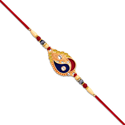 Elegant Wukusy fashion Rakhi with enamel paisley design and gold-tone embellishments, showcasing intricate craftsmanship.