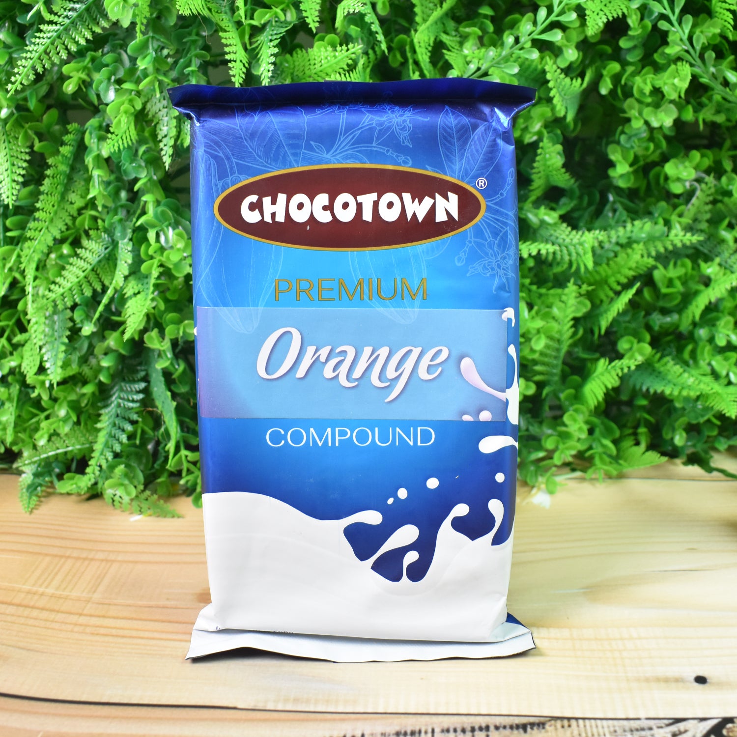 Wukusy Chocotown Premium Orange Compound 500g, vibrant orange-colored food product in a clear package.