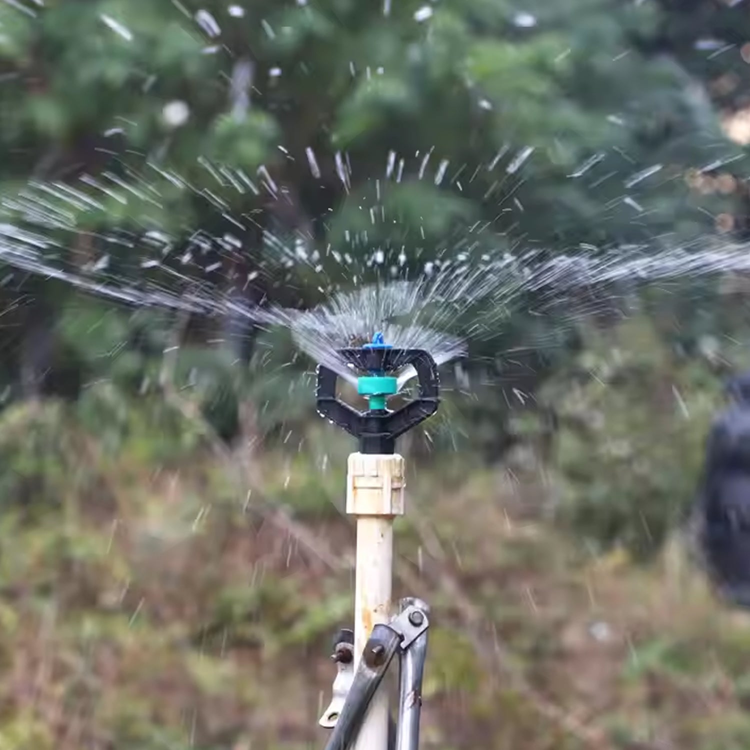 Wukusy garden rotating irrigation sprinkler nozzle, plastic spray head for efficient watering, shown outdoors in use