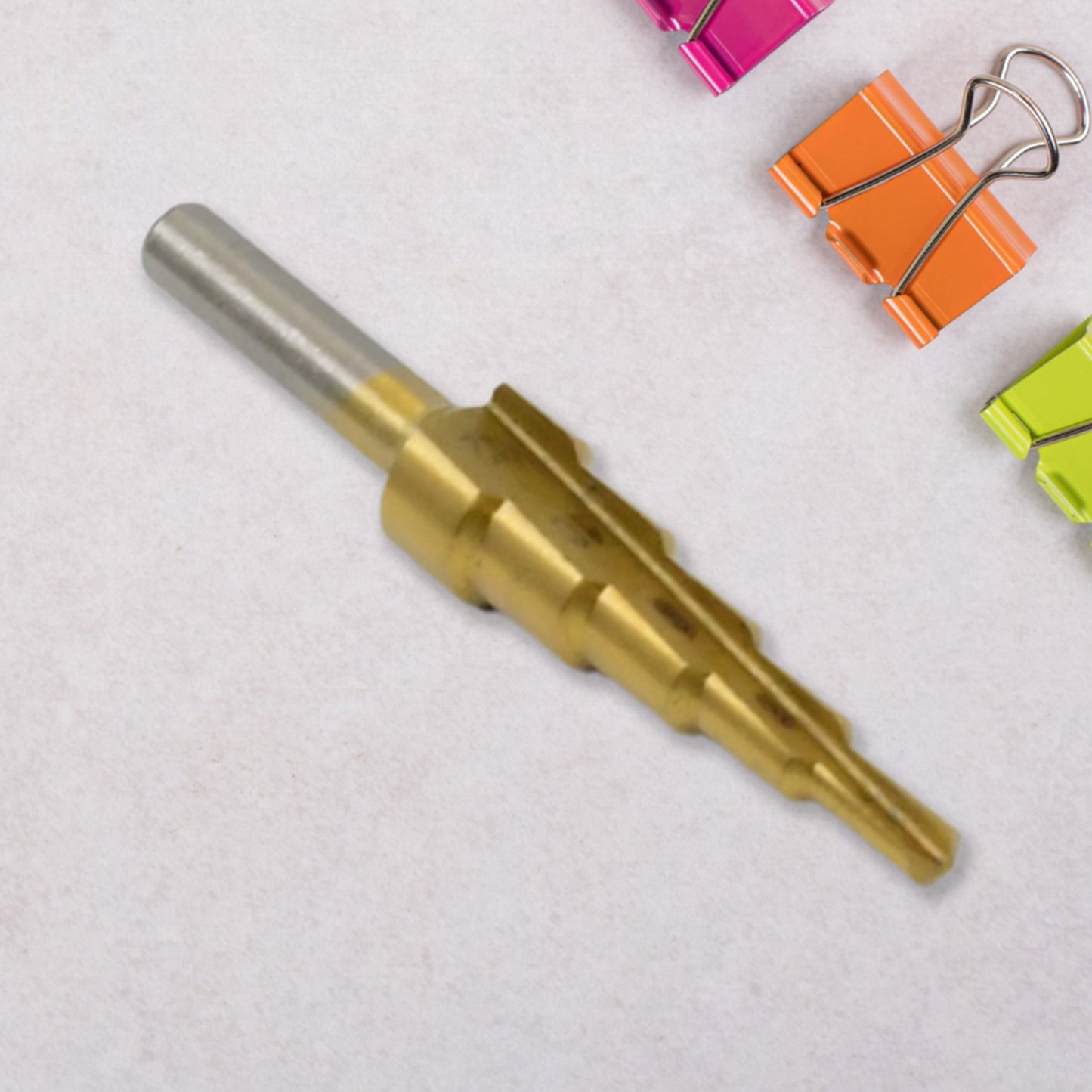Wukusy high-speed steel step drill bit for metal, 4-12mm, shown in close-up with metal shavings and drill tip.