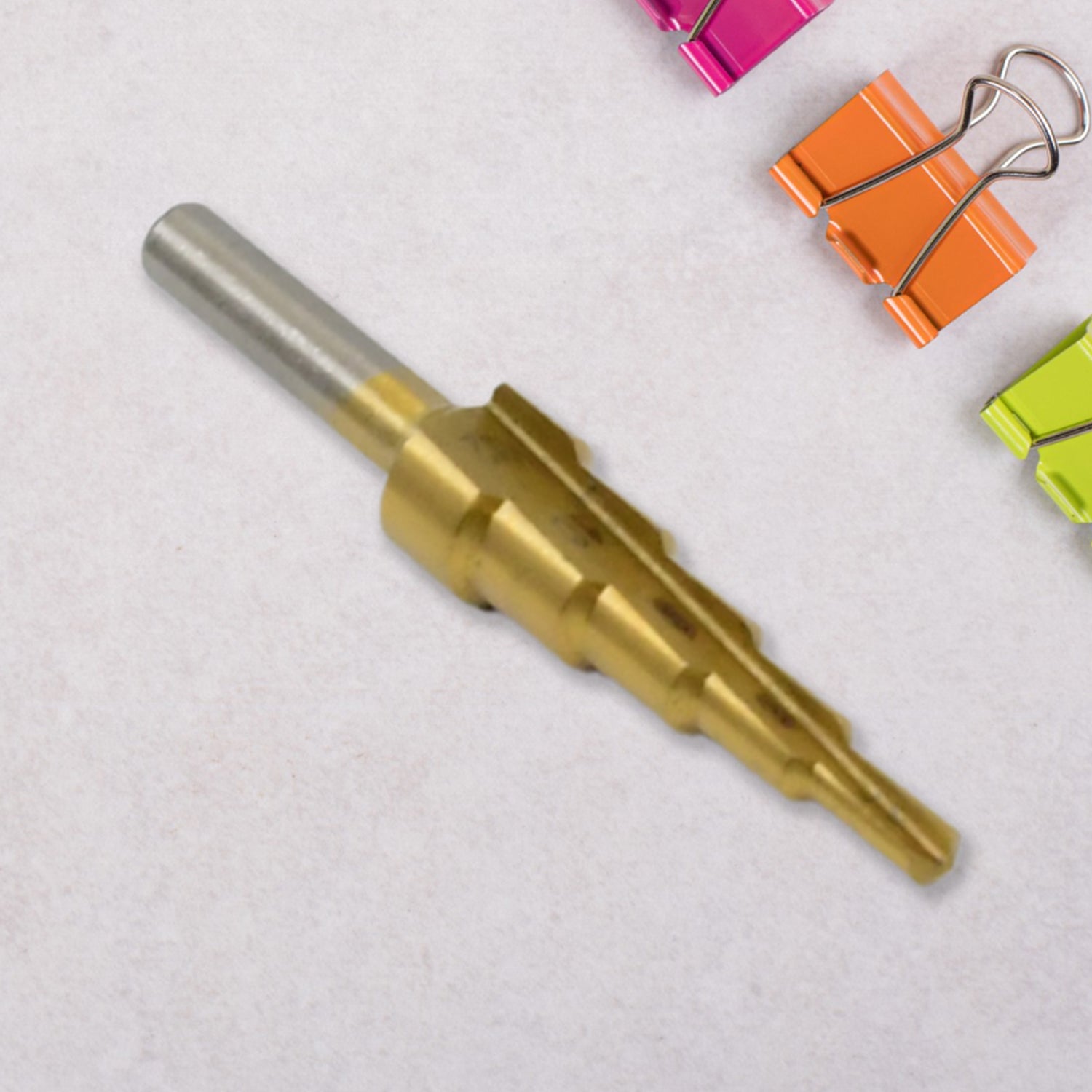 Wukusy high-speed steel step drill bit for metal, 4-12mm, shown in close-up with metal shavings and drill tip.