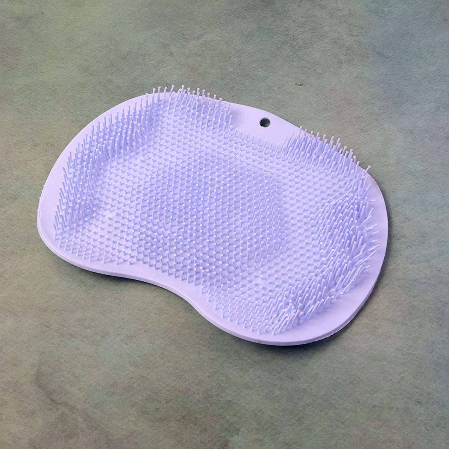 Green silicone bath massage cushion with suction cups and exfoliating foot scrubber mat for relaxing foot care.