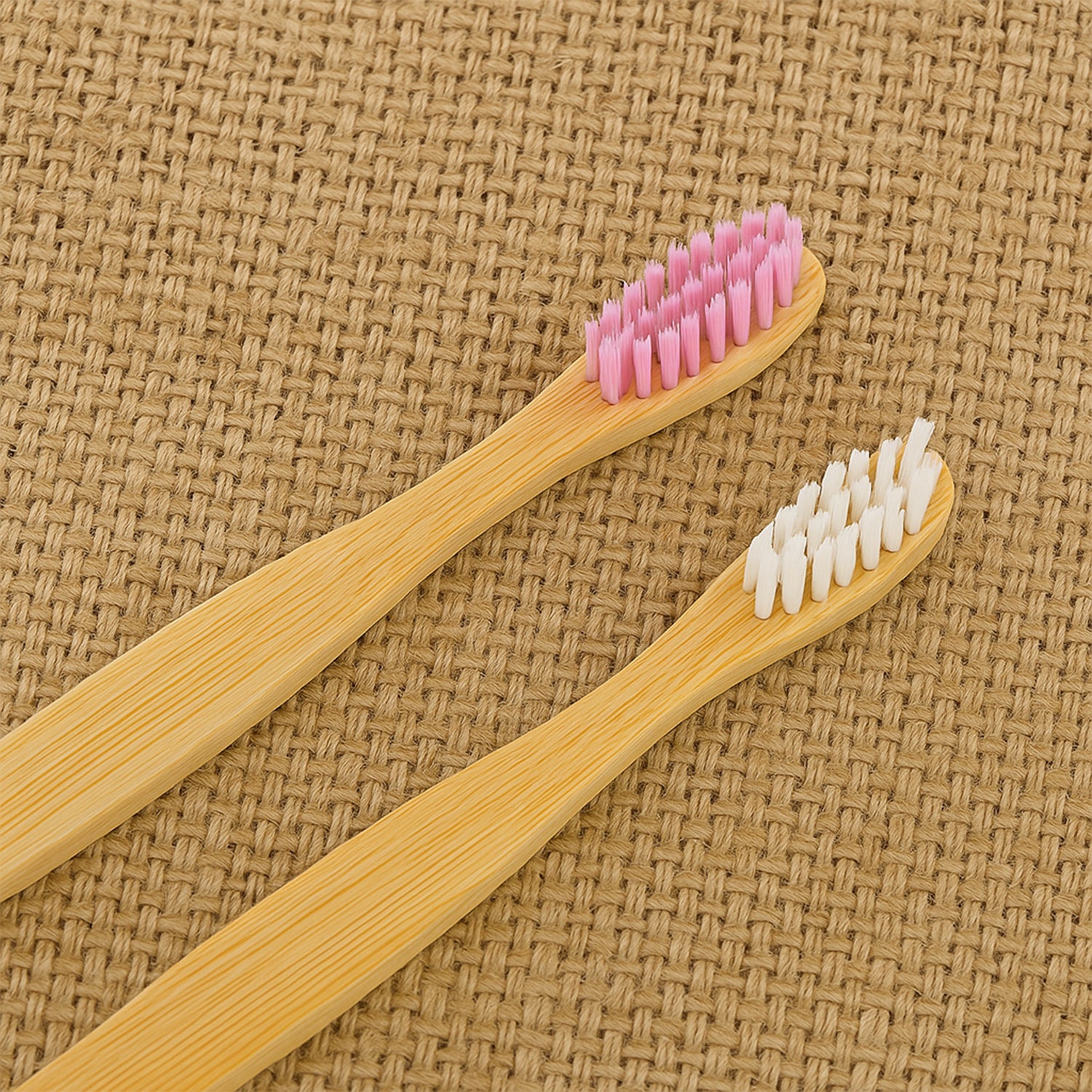 Two Wukusy eco-friendly bamboo toothbrushes with medium bristles, natural wood finish, and soft bristle heads for oral care.