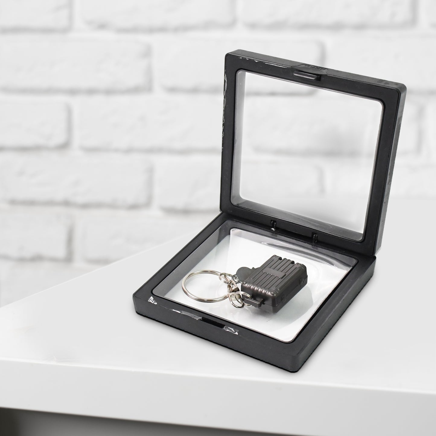 Wukusy suitcase-shaped nail clipper keychain with key in 3D floating frame display case, compact health care accessory.